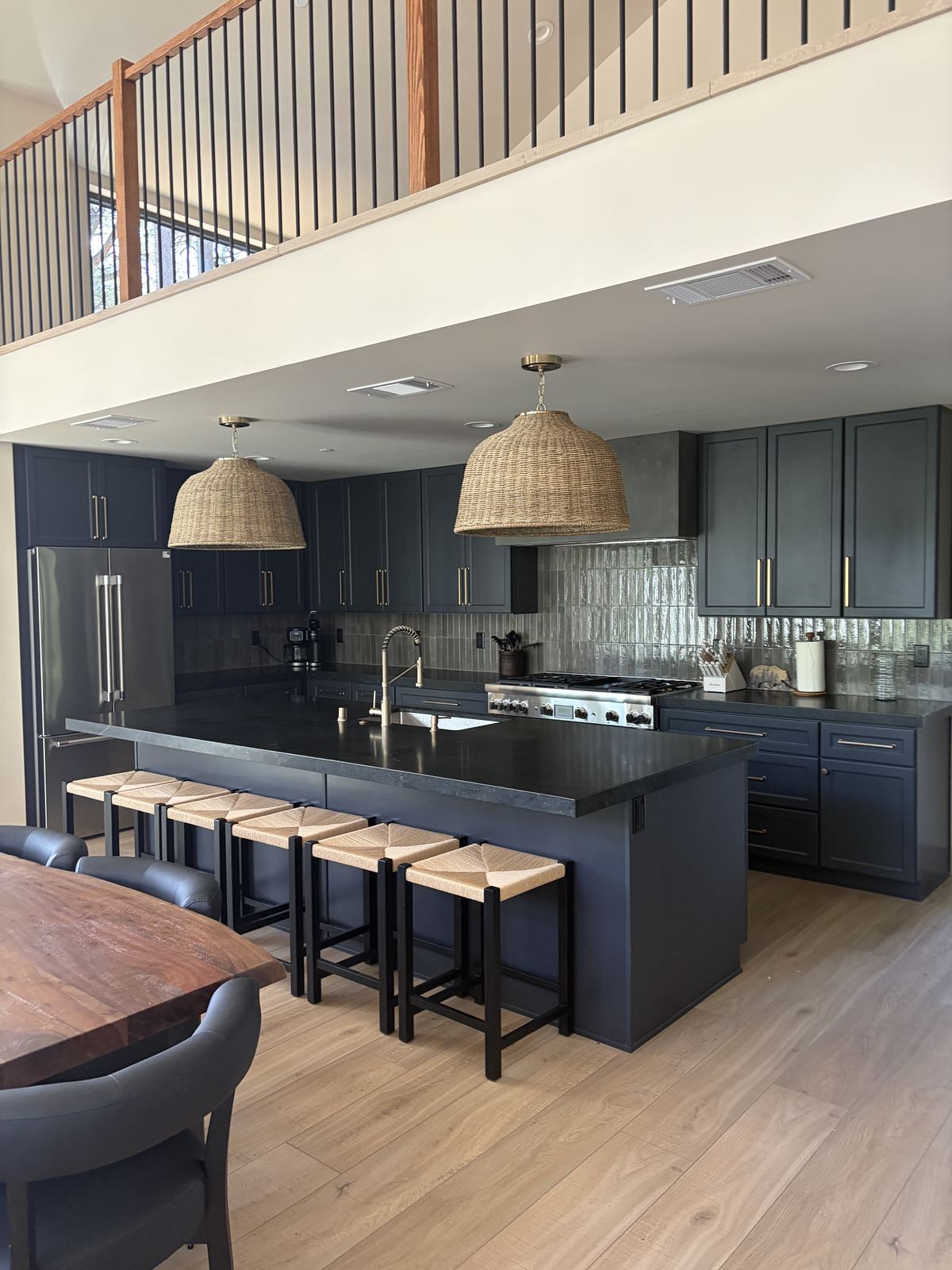 Navy kitchen with a long island, six stools and a gas range